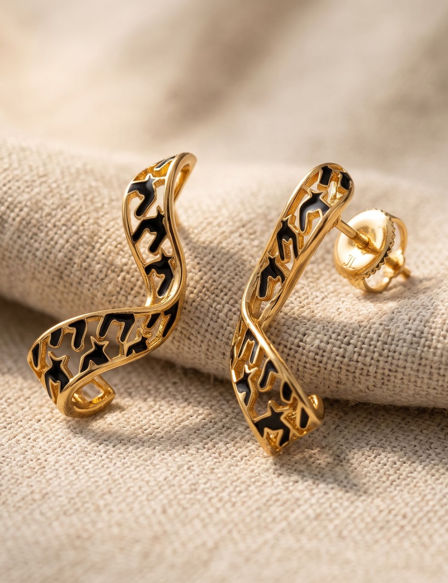 Crafted in 925 silver with gold plating, these earrings feature cloisonné enamel in a contemporary design. Inspired by the graceful movement of flowing ribbons, the sculptural silhouette and bold enamel detailing create a striking balance of fluidity and modern artistry.
