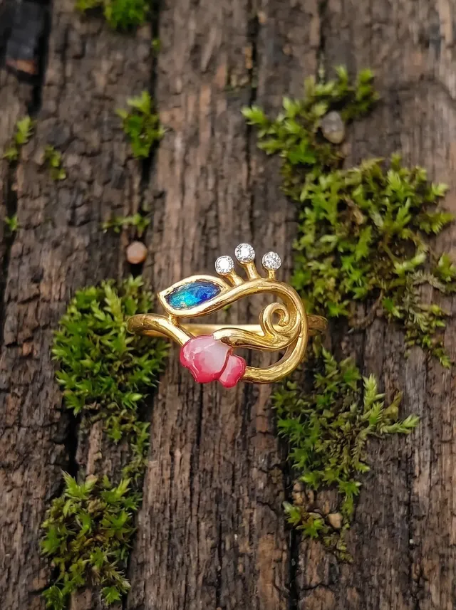 A contemporary ring inspired by blooming vines, featuring vibrant cloisonné enamel in shades of peacock blue, emerald green, and soft blush pink. Crafted in 925 silver with gold plating.