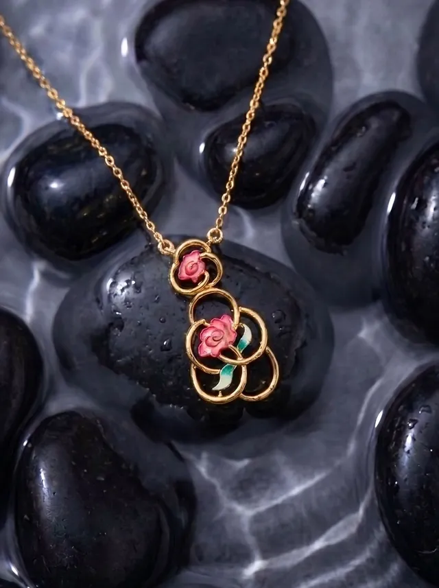 A romantic pendant in 925 gold-plated silver, featuring flowing circular forms adorned with champlevé enamel roses and Swarovski crystal accents for a soft, luminous sparkle.